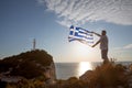 man with greece flag looking at sunset above the sea Royalty Free Stock Photo