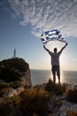 man with greece flag looking at sunset above the sea Royalty Free Stock Photo