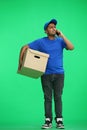 A man on a green background with box conversate on the phone Royalty Free Stock Photo