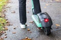 A man on a green electric bicycle scooter with a red brake light is ready to ride Royalty Free Stock Photo