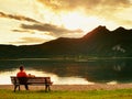 Man in green outdoor windcheater walk at lake bank. Royalty Free Stock Photo