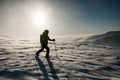 man in green and red ski suit with trekking poles walks through deep powdery snow Royalty Free Stock Photo