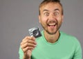 Man in green shirt holds a new condom in hand, joy of found a co Royalty Free Stock Photo