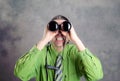 Man in green shirt and necktie looking through a binoculars Royalty Free Stock Photo