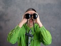 Man in green shirt and necktie looking through a binoculars Royalty Free Stock Photo