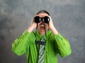 Man in green shirt and necktie looking through a binoculars Royalty Free Stock Photo