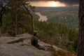 Man in green are sitting on tonekollen in ostmarka/oslo/norway enjoying the beautiful scenic view just before sunset with black st