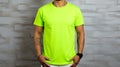 Man in green t shirt mockup template for design print studio on light gray wall, isolated