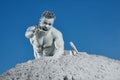 Man among grey sand screaming and showing by hand. Royalty Free Stock Photo