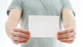 Man in a grey t-shirt holding a blank card