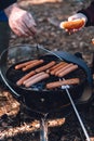 Man grill hot dogs in the forest