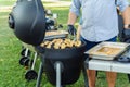 Man grilling chicken during a barbecue party in the garden in the summer