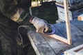 Man with grinding machine makes frame for bees. Create bee frame with your hands. Royalty Free Stock Photo