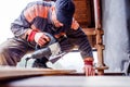 Man grinding planks of wood for home construction. Royalty Free Stock Photo