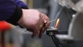 Man grinding small pieces of metal on the grind machine, industrial concept