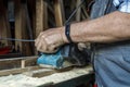 Man grinds the wood of angular grinding machine. Home carpentry workshop