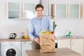 Man With Grocery Bag In Kitchen Room Royalty Free Stock Photo