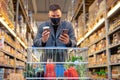 man in grocery store with cart checking phone Royalty Free Stock Photo