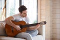 Man with guitar sitting on couch Royalty Free Stock Photo