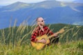 Man with guitar on top of mountain. Acoustic music. Summer music festival outdoors. Playing music. Sound of freedom Royalty Free Stock Photo