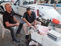 Man gutting a fish at the country turkish market with friend drinking tea