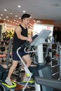 Asian chinese man in gym doing cardiovascular exercise