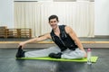 Man in gym making stretching exercises sitting on the floor Royalty Free Stock Photo