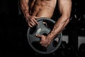 Man in gym. Muscular bodybuilder guy doing exercises with barbell. Strong person with Tense strong male hand with veins
