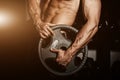 Man in gym. Muscular bodybuilder guy doing exercises with barbell. Strong person with Tense strong male hand with veins