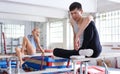 Man gymnast training gymnastic action at steel bars in gym, woman on background Royalty Free Stock Photo