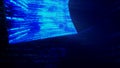 A man hacker in a hood in a dark room works with the program code