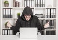 Man hacker using laptop and breaking open password in office Royalty Free Stock Photo