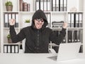 Man hacker using laptop and breaking open password in office Royalty Free Stock Photo