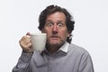 Man had too much coffee (holding mug), horizontal