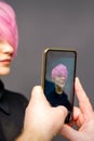 Man hairdresser& x27;s hands taking picture on smartphone of her client short pink hairstyle. Royalty Free Stock Photo