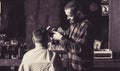 Man hairstylist. Hairdresser cutting hair of male client. Hairstylist serving client at barber shop. Man visiting Royalty Free Stock Photo