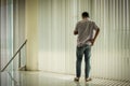 The man in the hallway with light and shadow from the curtain behind