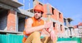 Man hammer take break working day at construction site. Builder vest and helmet construction site sit relaxing. Guy Royalty Free Stock Photo