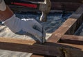 A man hammers a nail into a board for fastening the strapping beam Royalty Free Stock Photo