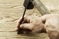 The man hammers a nail into a damaged surface Royalty Free Stock Photo