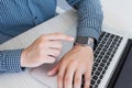 Man hand with Apple Watch and Macbook on the desk Royalty Free Stock Photo