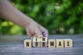 Man hand arranging wooden cubes with NEW NORMAL word. Adapting to new life or business post-lockdown after coronavirus pandemic