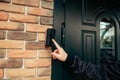 man hand in a black jacket rings the door intercom Royalty Free Stock Photo