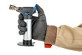 Man hand in black protective glove and brown uniform holding small butane torch isolated on white background Royalty Free Stock Photo
