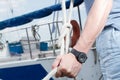 Man hand with boat rope. yachtsman tying sea knot. black Watches on man hand holding rope with knot. Closeup hands