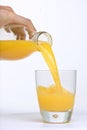 Man Hand, Bottle pouring Orange juice over glass Royalty Free Stock Photo