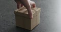 Man hand bring brown paper gift box on terrazzo countertop