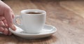 Man hand bring cup of fresh espresso on table