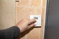 Man hand man changes the temperature on smart heating thermostat in interior house