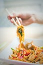 Man hand with chopsticks eat thai food closeup selective focus Royalty Free Stock Photo